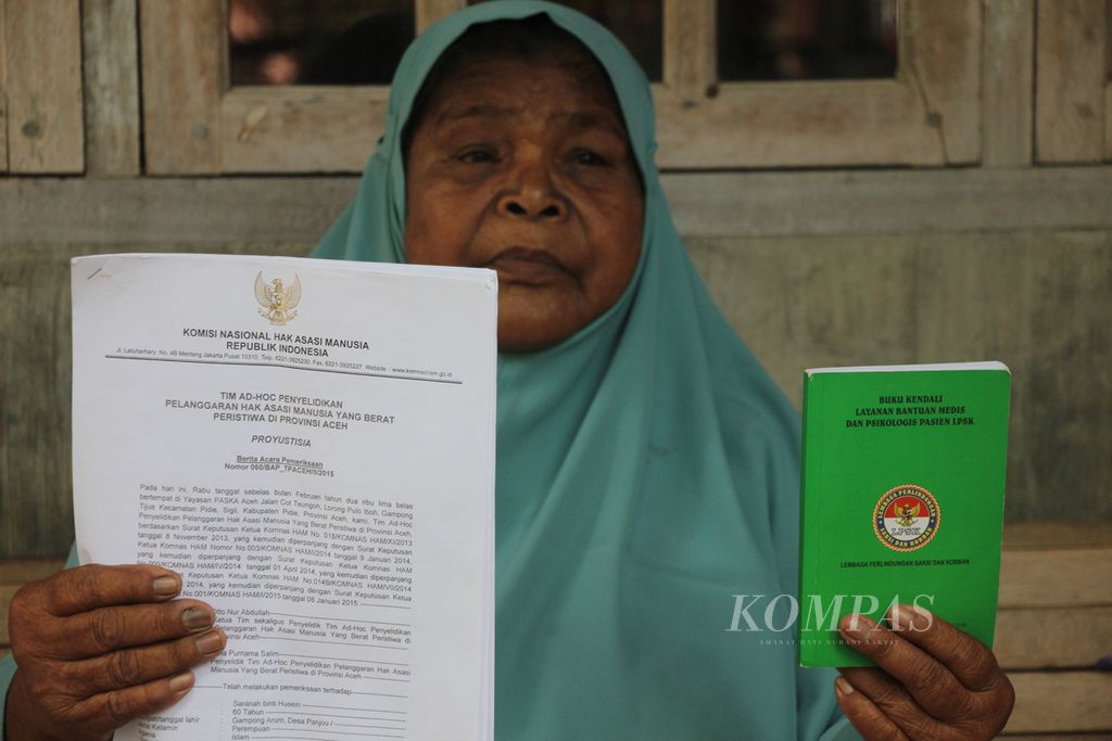 Saranah (70), warga Desa Panjo, Kecamatan Glumpang Tiga, Kabupaten Pidie, Aceh, memperlihatkan dokumen berita acara pemeriksaan (BAP) oleh Komnas HAM, Minggu (2/7/2023). Saranah adalah korban pelanggaran HAM berat di Rumoh Geudong, Aceh.