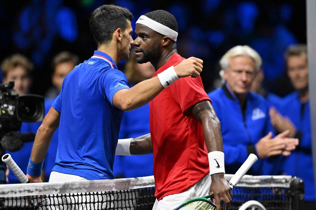 Novak Djokovic (kiri) merangkul Frances Tiafoe dari Tim Dunia yang dikalahkannya pada hari kedua turnamen tenis Piala Laver di O2 Arena, London, Minggu (25/9/2022) dini hari WIB. 