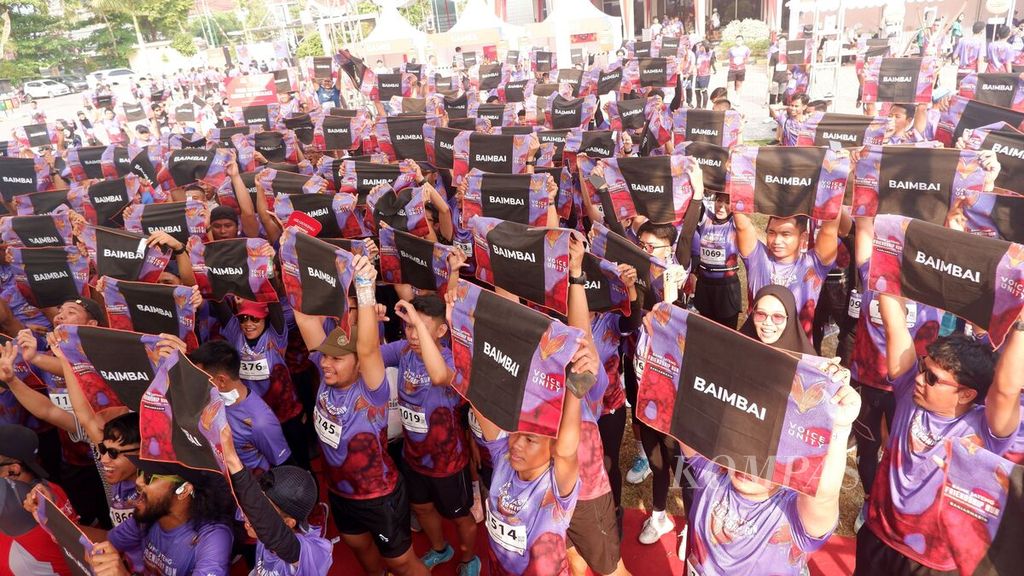 Peserta Bank Jateng Friendship Run Banjarmasin membentangkan handuk kecil bertuliskan Baimbai setelah berlari sejauh 5 kilometer di Banjarmasin, Kalimantan Selatan, Minggu (3/9/2023). 
