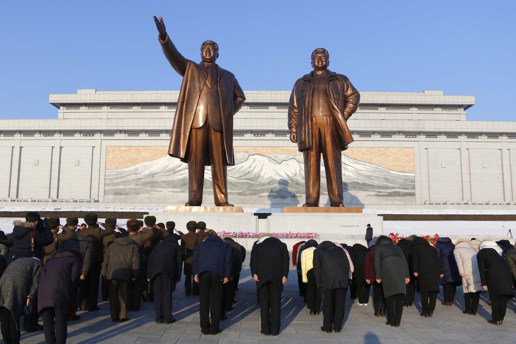 Warga Pyongyang membungkukkan badan, memberi pernghormatan kepada patung raksasa dua pendiri negara mereka, Kim Il Sung (kiri) dan Kim Jong Il (kanan), yang berada di Bukit Mansu, Rabu (16/2). Kegiatan ini adalah bagian dari kegiatan perayaan ulang tahun ke-80 Kim Jong Il. 