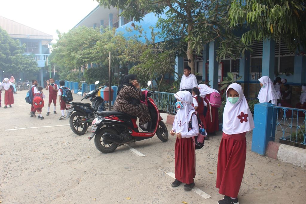 Sejumlah anak Sekolah Dasar Negeri 55 Palembang, Sumatera Selatan, menunggu jemputan di sekolahnya. Pemerintah meliburkan siswa TK hingga SMP sampai tiga hari ke depan karena kualitas udara yang terus memburuk. Asap tersebut muncul akibat kebakaran lahan yang terjadi di sejumlah daerah di Sumatera Selatan.
