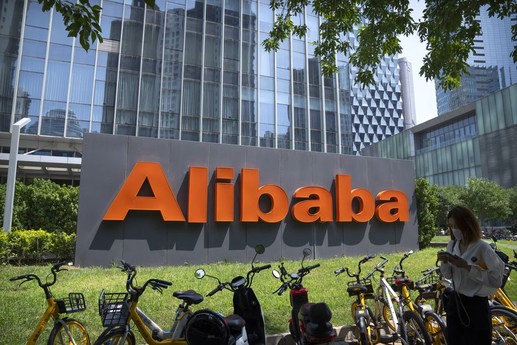 Seorang wanita berjalan melewati kantor perusahaan teknologi China, Alibaba, di Beijing, China, Selasa (10/8/2021).