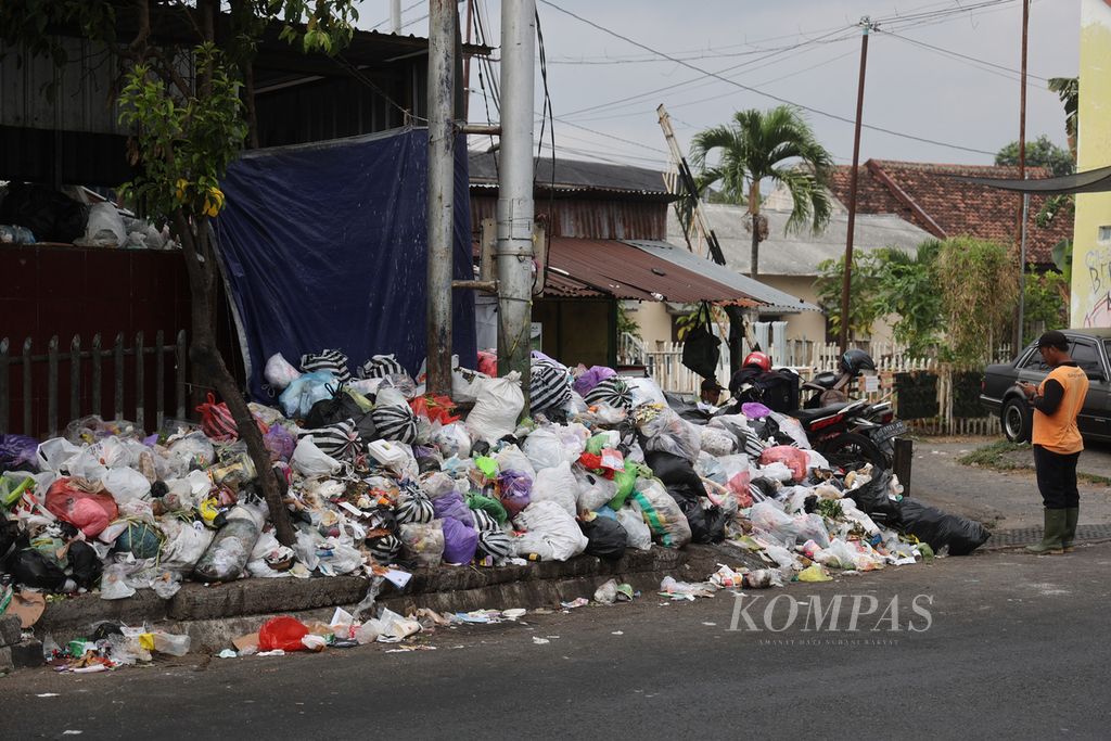 Petugas pemungut sampah berdiri di dekat tumpukan di kawasan Pengok, Yogyakarta, Kamis (14/9/2023). 