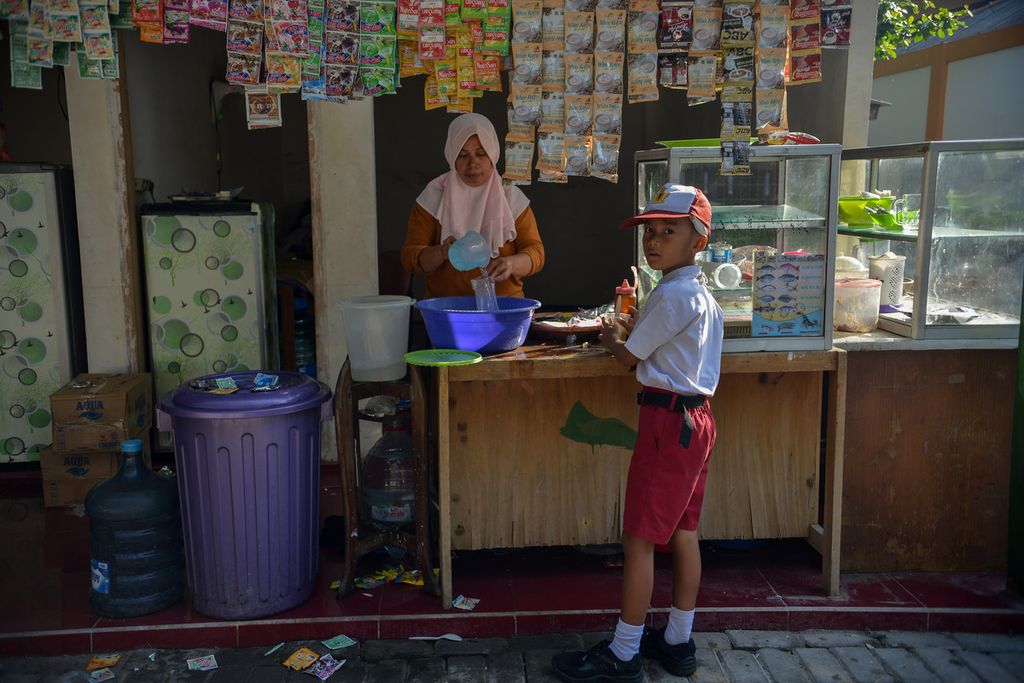 Seorang siswa jajan minuman di salah satu warung di Pulau Untung Jawa, Kepulauan Seribu, Jakarta, Senin (15/5/2023). 