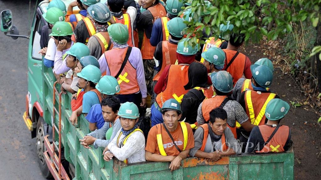 Para pekerja proyek infrastruktur naik di atas truk saat menuju lokasi kerja di Jalan TB Simatupang, Cilandak, Jakarta Selatan, Selasa (23/10/2018).