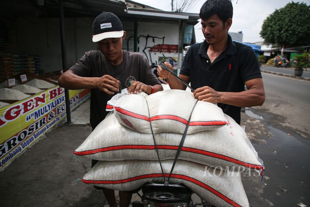 Pekerja mengikat karung berisi beras ke kendaraan pembeli di agen beras di kawasan Ciledug, Kota Tangerang, Banten, Senin (19/2/2024). 