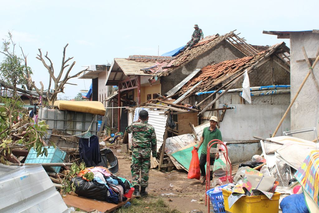 Petugas dan warga membersihkan puing-puing dan memperbaiki atap rumah yang terdampak puting beliung di Desa Mangunarga, Kecamatan Cimanggung, Kabupaten Sumedang, Jawa Barat, Sabtu (24/2/2024). Angin ribut yang melanda daerah tersebut, Rabu (21/4/2024), membuat puluhan warga mengungsi dan ratusan rumah rusak.