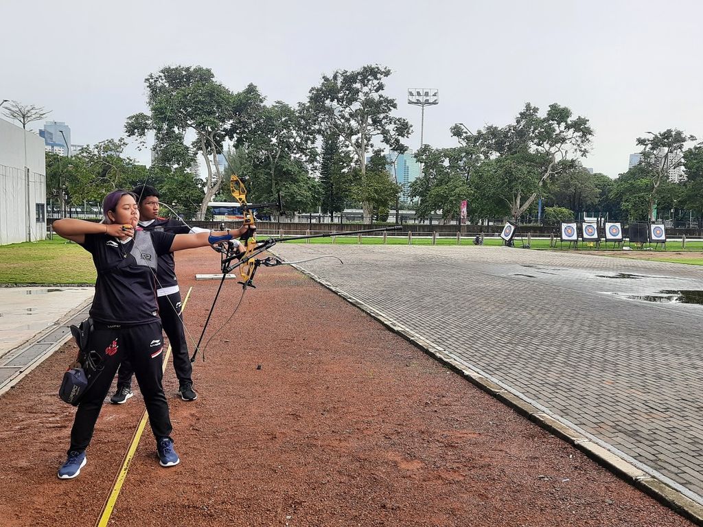 Atlet panahan tim nasional Lisnawanto Putra Aditya (19) dan Pande Putu Gina (17) sedang berlatih dalam kategori recurve perseorangan di Lapangan Panahan, Gelora Bung Karno, Jakarta, Kamis (17/11/2022). Keduanya tetap berlatih meski hujan mengguyur.