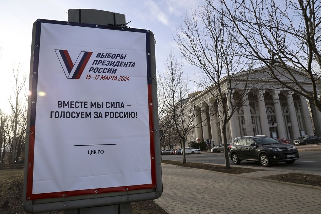 Sebuah papan reklame memuat promosi pemilihan presiden Rusia dengan kata-kata: ”Bersama kita kuat, pilihlah untuk Rusia!” di sebuah ruas jalan di Donetsk, wilayah Ukraina yang dikuasai Rusia, 13 Maret 2024. 