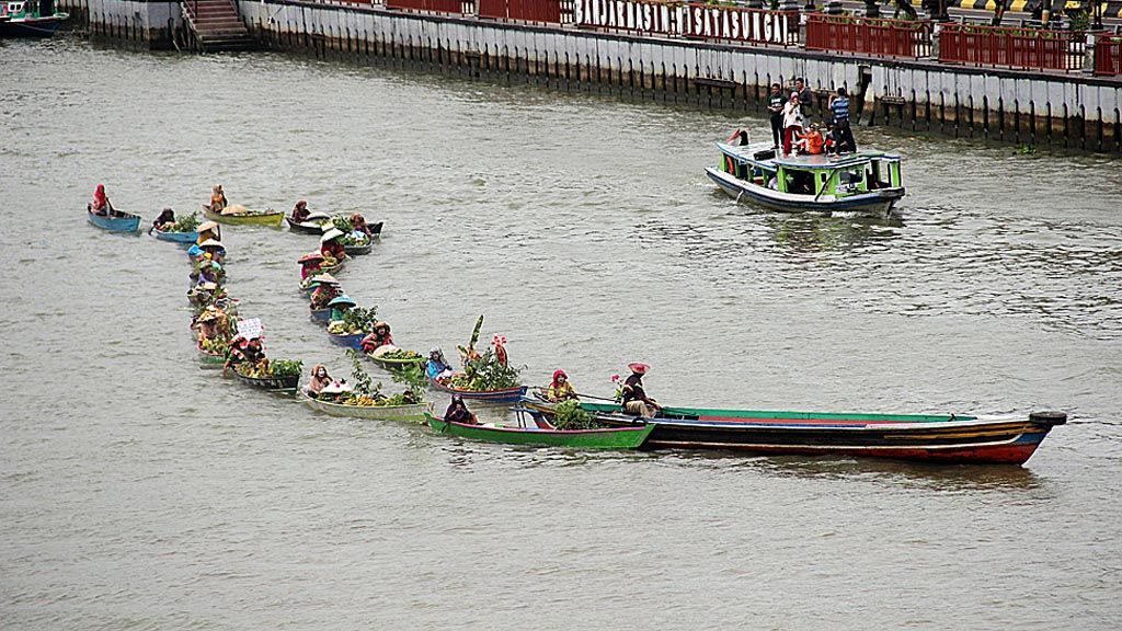 Para pedagang pasar terapung membentuk formasi jukung barenteng (perahu  berangkaian) dalam Festival Jukung Bungas Indonesia 2017 di Sungai Martapura, Kota Banjarmasin, Kalimantan Selatan, Sabtu (23/9).  