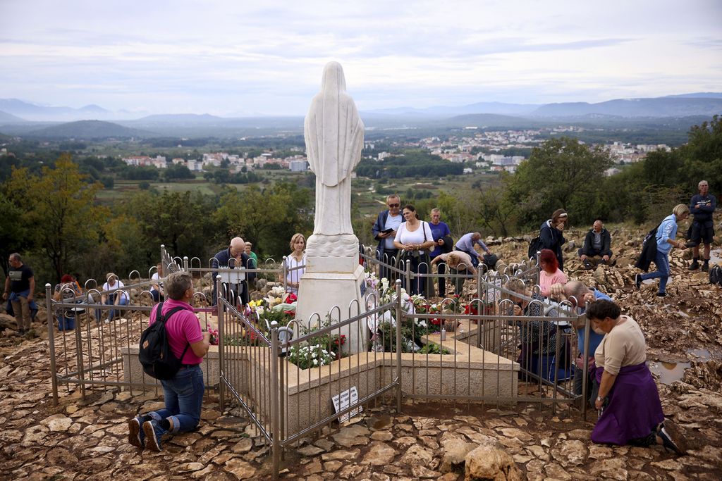 Peziarah berdoa di kaki patung Bunda Maria di sebuah bukit yang diyakini sebagai tempat terjadinya penampakan Bunda Maria di Desa Medjugorje, Bosnia-Herzegovina, Kamis (19/9/2024). 