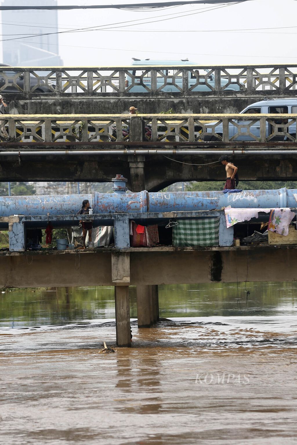 Warga miskin beraktivitas pada jembatan pipa air bersih yang merangkap sebagai tempat tinggalnya di atas Sungai Ciliwung di kawasan Tanah Abang, Jakarta, Minggu (16/10/2022). Sejumlah kalangan pesimistis terhadap target pemerintah dalam menurunkan angka kemiskinan di tengah tingginya tekanan ekonomi global pada tahun 2023. 