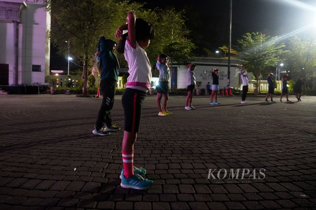 Nameeya Azkya Widyahapsari (8), salah satu peserta lomba lari Semarang 10K kategori Kids Dash, melakukan pemanasan sebelum latihan bersama komunitas pelari Semarang Runners di Kota Semarang, Jawa Tengah, Kamis (8/12/2022). 