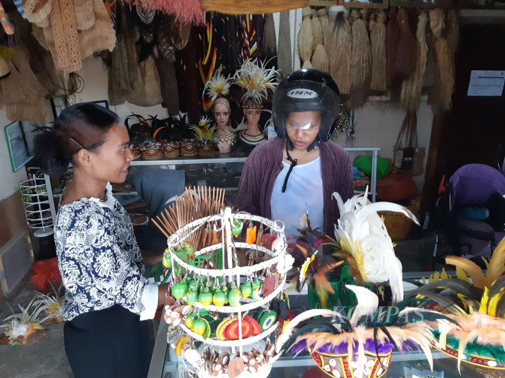 Pemilik galeri Wadomu Art, Maryana Rumbiak (baju bercorak warna putih hitam) melayani salah satu pembeli yang mengunjungi tempatnya di Distrik Abepura, Kota Jayapura, Papua, pada 26 Agustus 2023. 