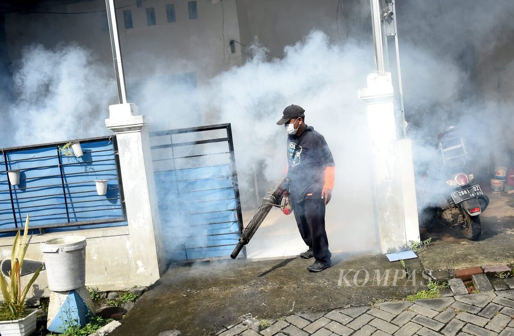 Petugas keluar dari rumah warga seusai melakukan pengasapan (<i>fogging</i>) di Kompleks Puri Maharani, Kecamatan Sukodono, Kabupaten Sidoarjo, Jawa Timur, Minggu (3/7/2022).