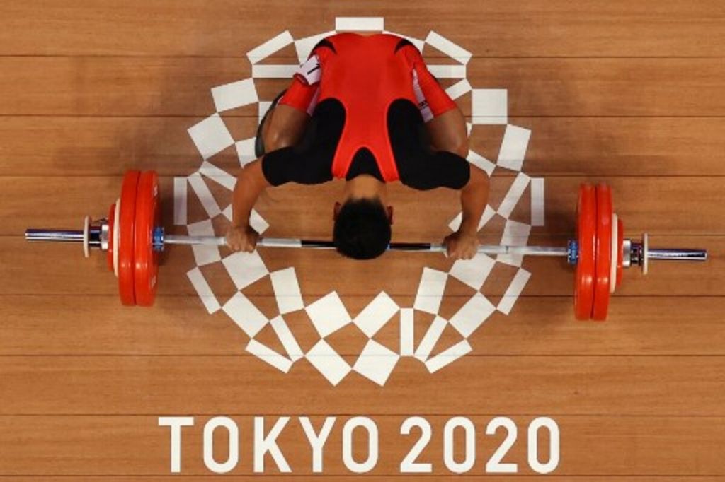 Lifter asal Indonesia, Eko Yuli Irawan, mengambil ancang-ancang dalam kompetisi angkat besi 61 kg putra Olimpiade Tokyo 2020 di Tokyo International Forum, Tokyo, Minggu (25/7/2021).