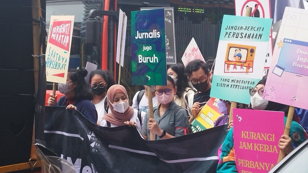 Para pekerja yang tergabung dalam Serikat Pekerja Media dan Industri Kreatif untuk Demokrasi (Sindikasi) berjalan sembari membawa spanduk-spanduk bertuliskan kritik dalam Hari Buruh Sedunia di Jakarta, Senin (1/5/2023).