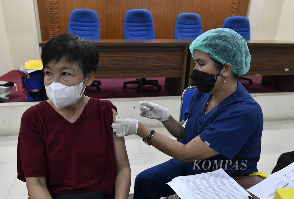 The vaccinator injects a second booster dose of the Covid-19 vaccine to an elderly woman during vaccination at the Central Jakarta Mayor's Office in Jakarta, Wednesday (25/1/2023).