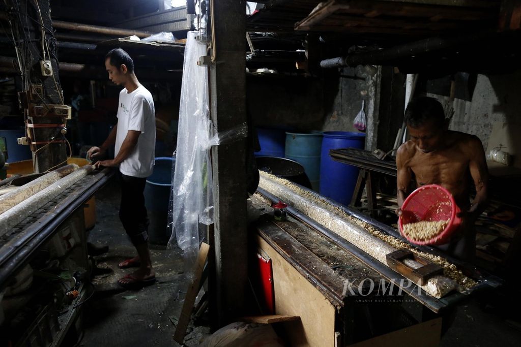 Perajin sedang mengolah kedelai untuk dijadikan tempe di sentra pembuatan tempe di kawasan Kemayoran, Jakarta Pusat, Rabu (18/1/2023).