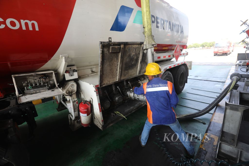 Operator truk pengangkut bahan bakar minyak mengisi tangki dengan<i> arm</i> saat pendistribusian BBM di salah satu pompa Terminal Terpadu Pertamina Plumpang, Jakarta Utara, Selasa (27/9/2022). 