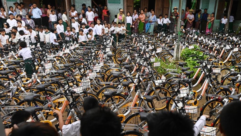 Siswa melihat sepeda-sepeda bekas yang dikirim dari Singapura di pinggiran kota Yangon, Myanmar, Selasa (18/6/2019). Sepeda-sepeda bekas dari perusahaan <i>bike-sharing</i> di Singapura itu akan disumbangkan sebagai bagian dari program Lesswalk di pinggiran Yangon. 