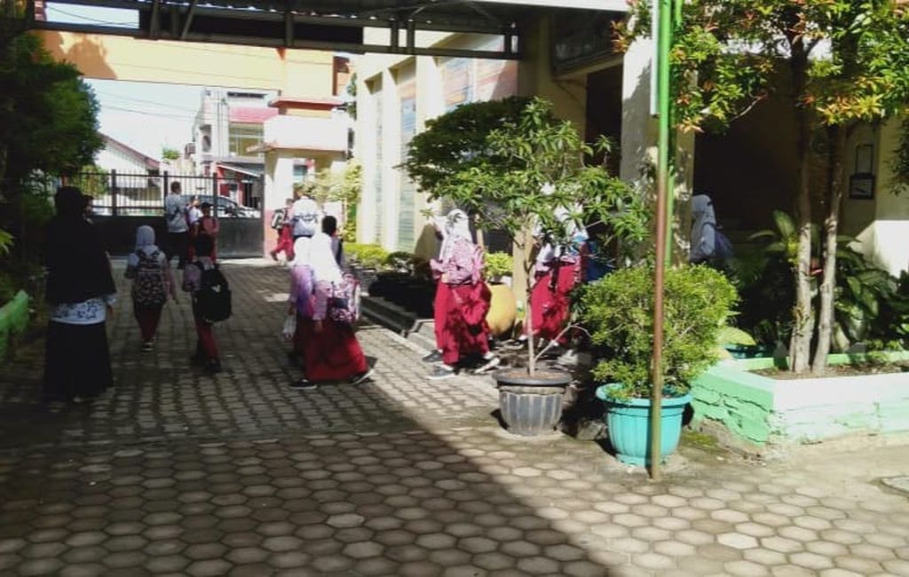 Siswa SDN 23 Ujung Gurun meninggalkan sekolah mereka saat proses penyemprotan disinfektan oleh BPBD Padang, Kelurahan Ujung Gurun, Padang Barat, Padang, Sumatera Barat, Rabu (2/2/2022). Ada 15 kasus Covid-19 ditemukan di kompleks sekolah ini hingga Rabu siang.