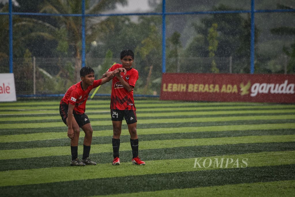 Pemain Putra Agung, Febriansyah Al Ghifari (kanan), membantu rekannya yang kecewa atas kekalahan melawan BM IFA dalam laga babak utama Liga Kompas Kacang Garuda U-14 di Dewantara Sport Center, Tangerang Selatan, Banten, Minggu (31/12/2023). 