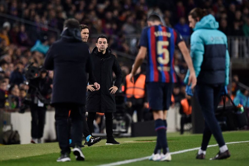 Pelatih Barcelona Xavi Hernandez menunggu kapten Barcelona, Sergio Busquets, yang ditarik keluar karena cedera pada laga Liga Spanyol antara Barcelona dan Sevilla di Stadion Camp Nou, Barcelona, 5 Februari 2023.