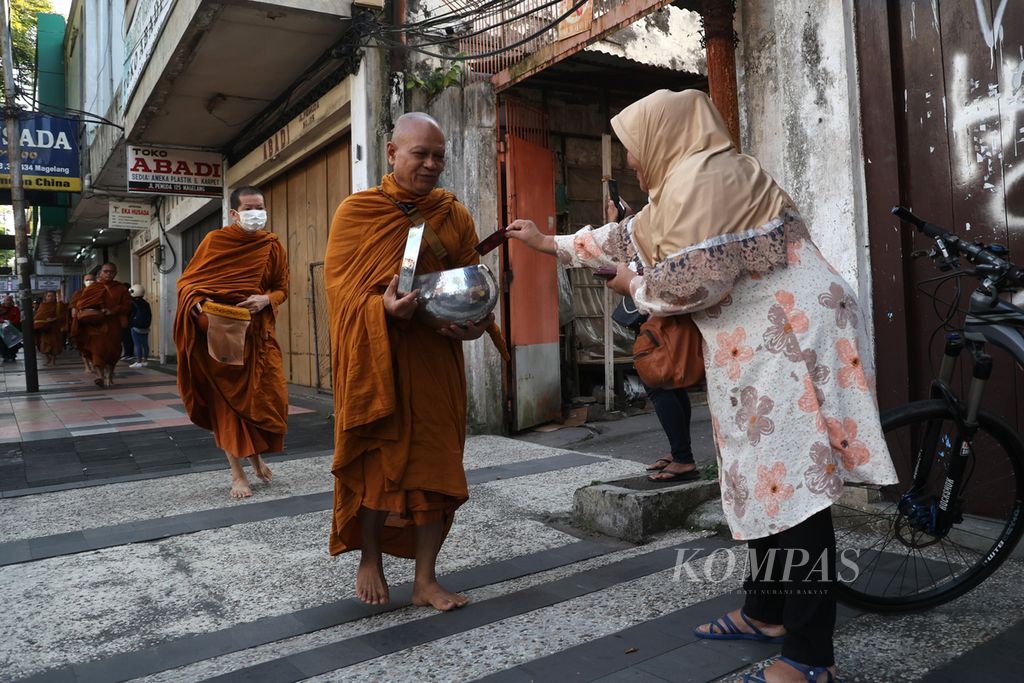 Umat Islam  ikut memberikan derma kepada biksu yang melakukan tradisi pindapata di Jalan Pemuda, Kota Magelang, Jawa Tengah, Rabu (31/5/2023). 
