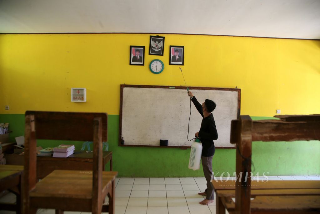 Daniel, guru honorer di SDN Tamansari 4, Rumpin, Bogor melakukan penyemprotan desinfektan di ruang kelas sekolah, Sabtu (24/10/2020). Meski tidak ada kegiatan pembelajaran secara tatap muka, guru-guru di SDN Tamansari 4 rutin melakukan penyemprotan desinfektan untuk menjaga lingkungan sekolah tetap sehat.