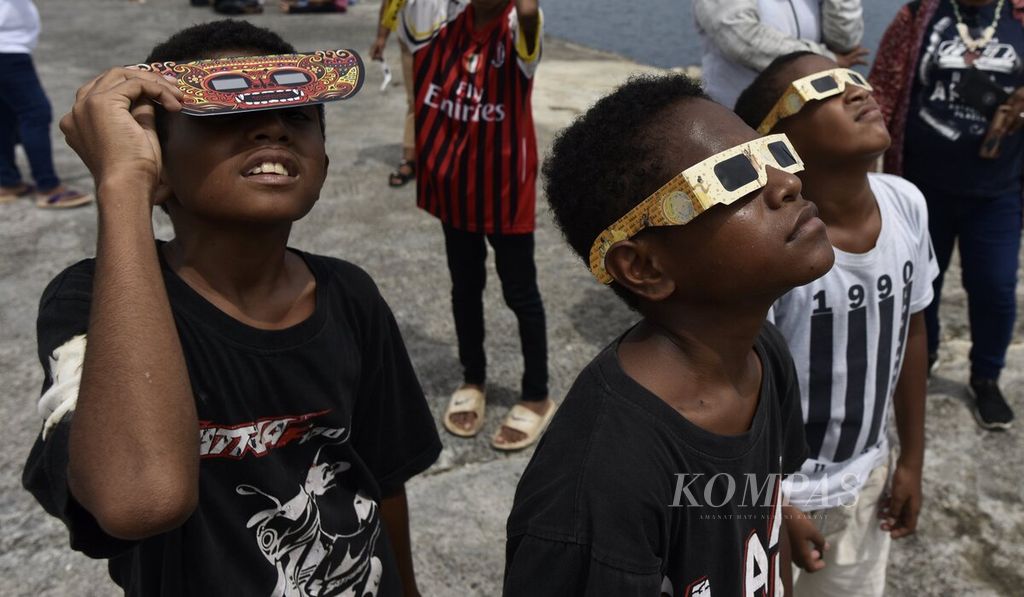 Dengan memakai kacamata matahari, anak-anak terlihat antusias menyaksikan fase demi fase gerhana Matahari total dari lokasi pengamatan di Pelabuhan BMJ, Biak, Papua, Kamis (20/4/2023). 