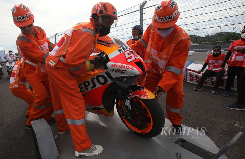 Tim marshal memindahkan motor Marc Marquez, pebalap tim Honda, yang terjatuh pada sesi kualifikasi MotoGP seri Indonesia di Sirkuit Internasional Jalan Raya Pertamina Mandalika, Lombok Tengah, NTB, Sabtu (19/3/2022). 