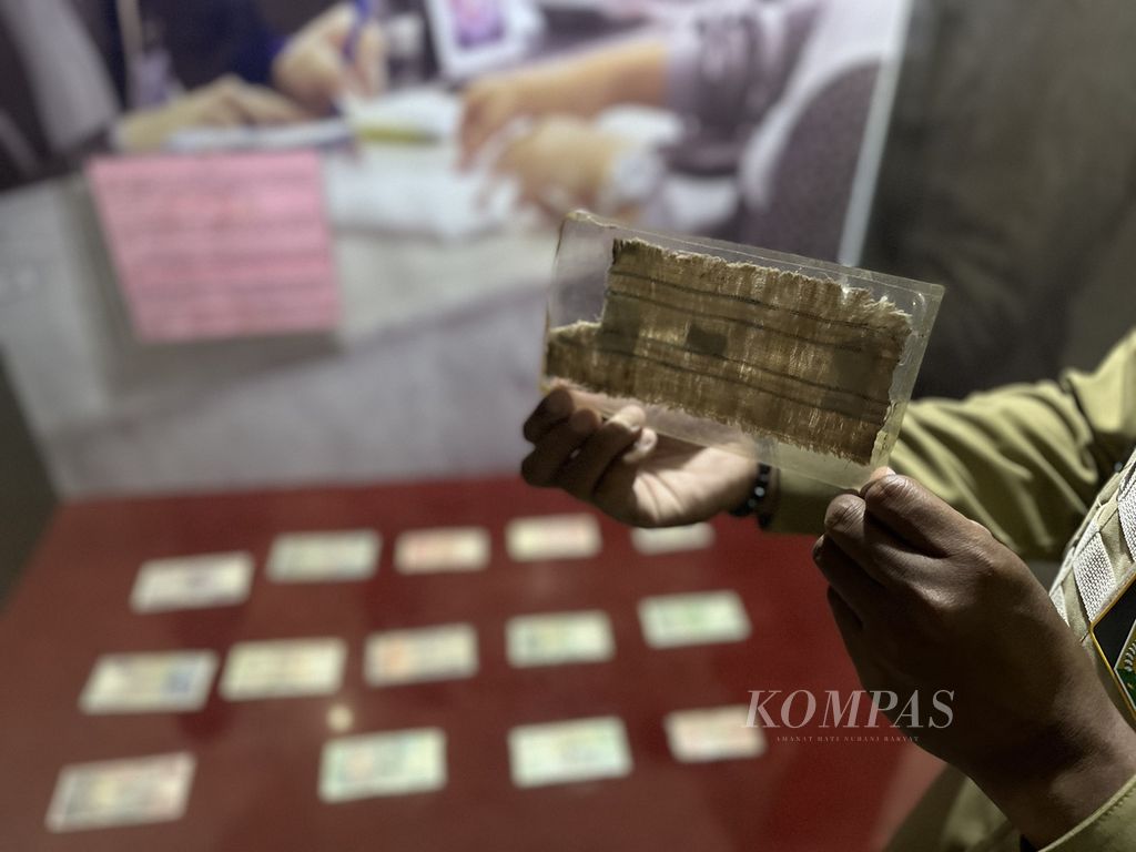 Kurator Museum Sultra menunjukkan mata uang kampua, yang lahir sejak abad ke-14, di Kendari, Sulawesi Tenggara, Selasa (28/6/2022). Mata uang ini diklaim yang pertama dan satu-satunya menggunakan kain tenun di masa itu.