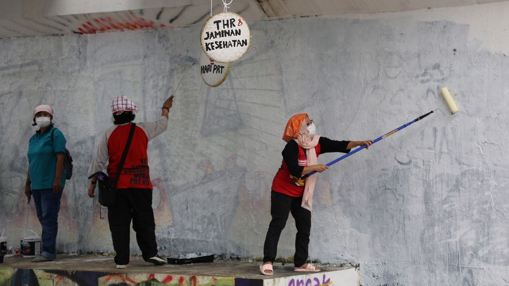 Pekerja rumah tangga (PRT) mengecat tembok penyangga jembatan yang akan dilukisi mural di Jembatan Kewek, Kotabaru, Yogyakarta, Rabu (15/12/2021). Mereka menggelar aksi untuk memprotes pembahasan RUU Perlindungan Pekerja Rumah Tangga yang masih terkatung-katung selama belasan tahun. Aksi itu juga sebagai wujud protes terhadap masih sering terjadinya tindakan kekerasan yang dilakukan para majikan terhadap PRT. Mereka juga menuntut pemenuhan sejumlah hak mereka melalui aksi itu.