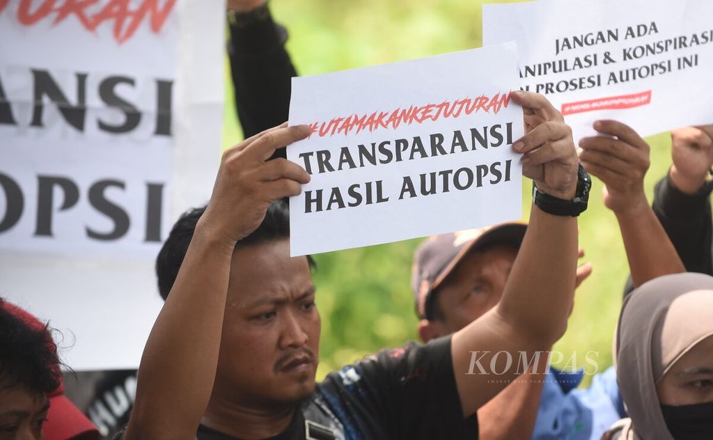 Aremania membawa poster saat berlangsung otopsi kepada dua korban Tragedi Kanjuruhan, yaitu NDR dan NDB, di Tempat Pemakaman Umum Dusun Patuk, Desa Sukolilo, Kecamatan Wajak, Kabupaten Malang, Jawa Timur, Sabtu (5/11/2022). 