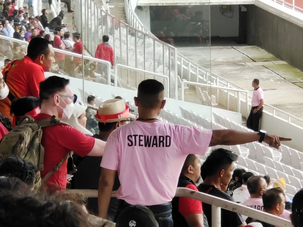 Petugas <i>steward</i> mengarahkan penonton di salah satu tribune Stadion Gelora Bung Karno, Jakarta, saat laga Piala AFF 2022 antara Indonesia dan Kamboja, Jumat (23/12/2022). Laga itu menjadi pertandingan pertama di Indonesia yang dihadiri penonton seusai Tragedi Kanjuruhan. 