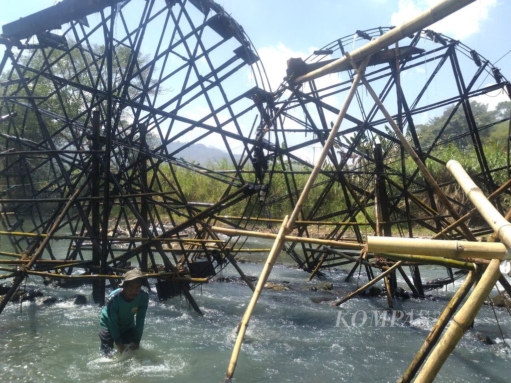 Petani di Sukasirna, Desa Cimanggung, Kecamatan Rajapolah, Tasikmalaya, Jawa Barat membersihkan sampah diantara kincir air, Rabu (13/9/2023). Kincir di Sungai Citanduy itu selalu dibuat saat kemarau tiba.