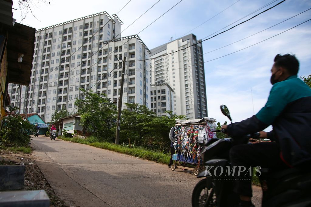 Suasana perkampungan dengan latar belakang apartemen di kawasan Sampora, Tangerang, Banten, Sabtu (19/3/2022). Pasar apartemen di Jakarta dan sekitarnya diprediksi terus bertumbuh tahun ini setelah terpuruk saat wabah Covid-19 melanda dunia awal 2020.