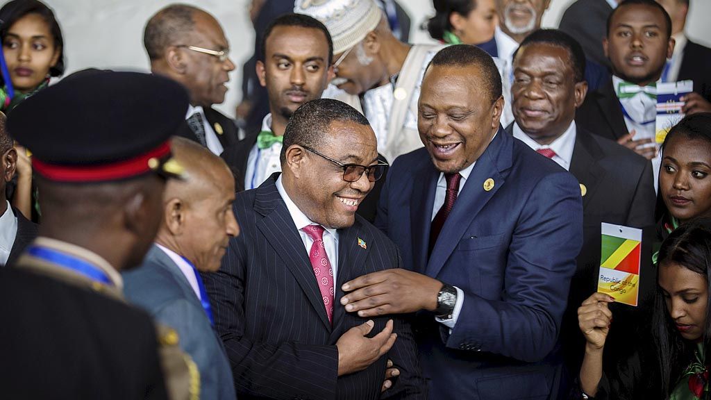 Presiden Kenya Uhuru Kenyatta (tengah) tertawa bersama Perdana Menteri Etiopia Hailemariam Desalegn (kiri), 28 Januari lalu, dalam pembukaan KTT Uni Afrika di Addis Ababa, Etiopia. Desalegn seminggu silam mundur.