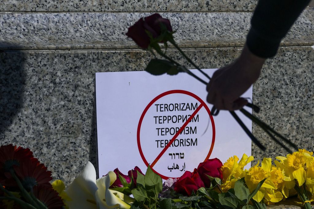 Seorang perempuan meletakkan bunga di monumen penyair terkenal Rusia, Aleksander Pushkin, di Beograd, Serbia, pada 23 Maret 2024, menyusul serangan di Balai Kota Crocus di Moskwa yang diklaim oleh kelompok NIIS.