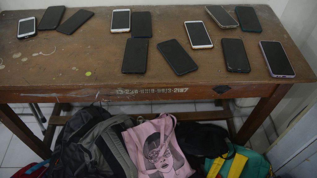 Telepon genggam dan tas milik peserta simulasi Asesmen Nasional Berbasis Komputer (ANBK) diletakkan di sisi depan ruang kelas di SMP Negeri 12 Yogyakarta, Jetis, Yogyakarta, Kamis (16/9/2021).