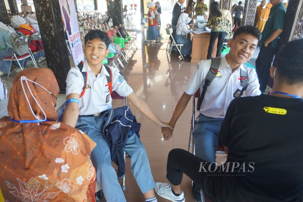 Para siswa bergandengan tangan saat diambil darahnya dalam program skrining Thalassemia yang digelar Prodia di Pendopo Kabupaten Purbalingga, Jawa Tengah, Selasa (26/9/2023).