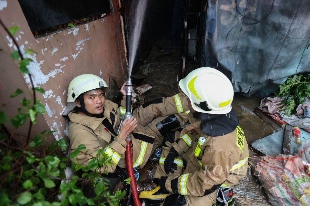 Dua petugas pemadam kebakaran memegang selang saat melakukan pendinginan di Jalan Dr Saharjo, Kecamatan Setiabudi, Jakarta, Kamis (11/1/2024). 