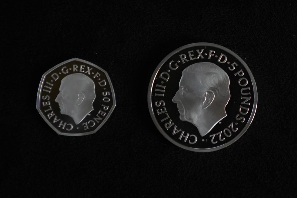 Dua koin baru bergambar potret Raja Charles III senilai 50 penny (kiri) dan 5 pound merupakan koin pertama bergambar wajah raja Inggris yang baru dan dipamerkan saat jumpa pers di London, Kamis (29/9/2022). 