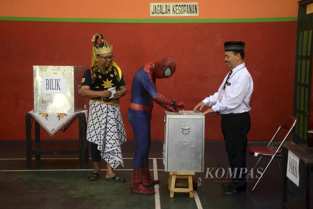 Pemilih yang menggunakan kostum tokoh pahlawan super Spiderman dan tokoh wayang menggunakan hak pilih mereka dalam pilkada di TPS 01, Kelurahan Gayam, Kecamatan Sukoharjo, Kabupaten Sukoharjo, Jawa Tengah, 27 Juni 2018. 