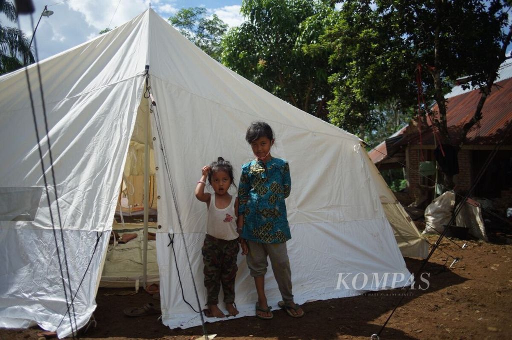 Dua anak bersiap masuk ke tenda di posko pengungsian SD Negeri 22 Talamau di Nagari Kajai, Kecamatan Talamau, Kabupaten Pasaman Barat, Sumatera Barat, Sabtu (26/2/2022). Pasaman Barat dan sekitarnya dilanda gempa bermagnitudo 6,1 pada 25 Februari lalu.