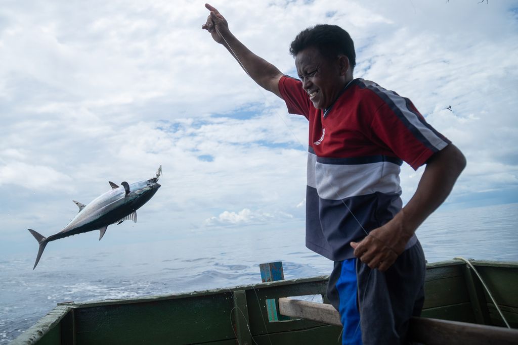 Rustam (48) menangkap ikan tongkol di perairan yang berjarak sekitar 45 kilometer di sebelah timur Pulau Natuna Besar, Kepulauan Riau, Sabtu (26/3/2022).