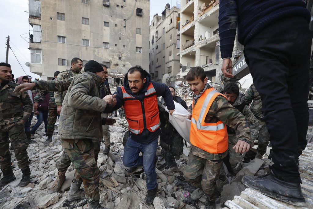 Tim penyelamat membawa jenazah korban dari sebuah bangunan yang hancur setelah gempa dahsyat mengguncang Suriah dan Turki di Aleppo, Suriah, Selasa (7/2/2023). 