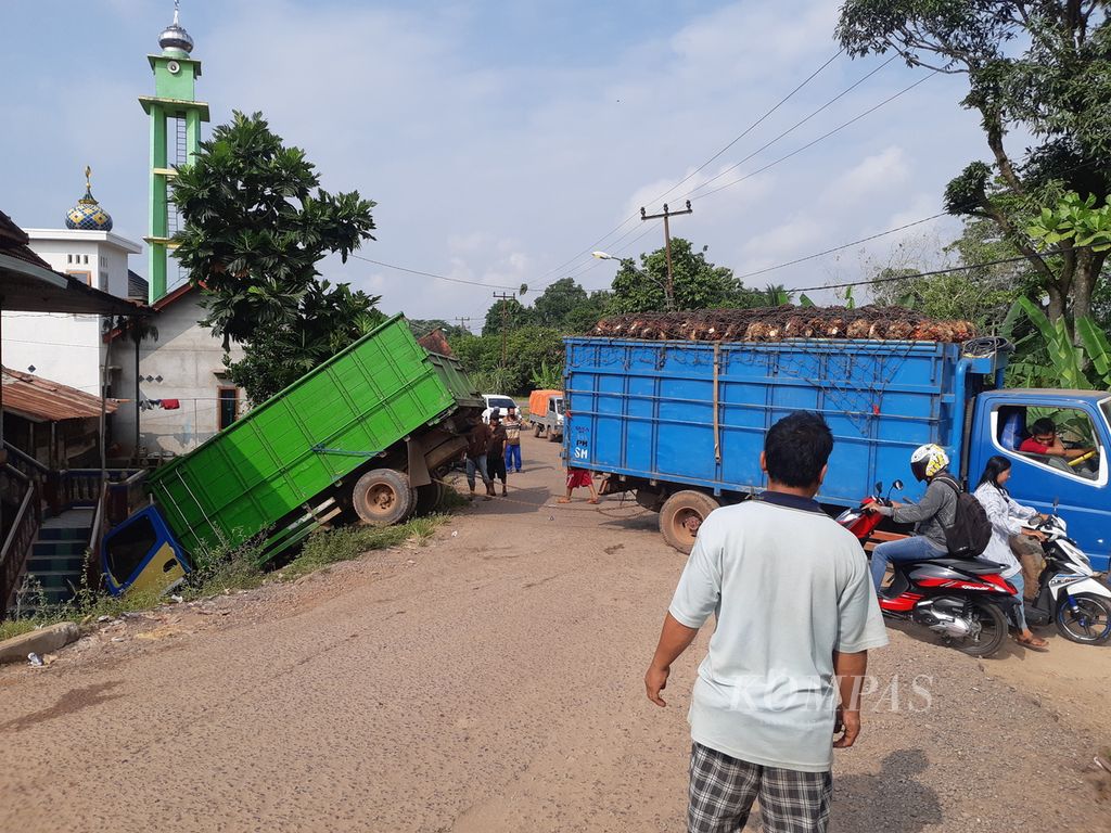 Sebuah truk terjerembab akibat jalan rusak di Desa Ulak Pati, Kecamatan Pampangan, Kabupaten Ogan Komering Ilir, Sumatera Selatan, Selasa (23/5/2023). 