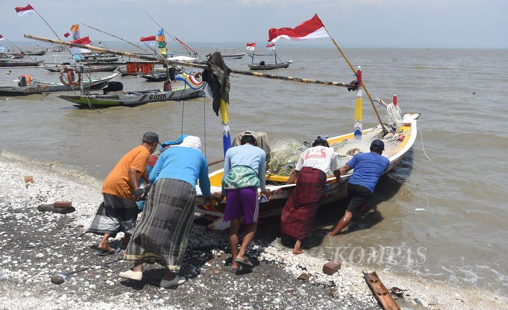 Nelayan mendorong perahu saat akan melaut di Pantai Nambangan, Surabaya, Senin (30/10/2023). Pemerintah Kota Surabaya terus menata kawasan pesisir agar lebih layak untuk dijadikan tempat berwisata. 